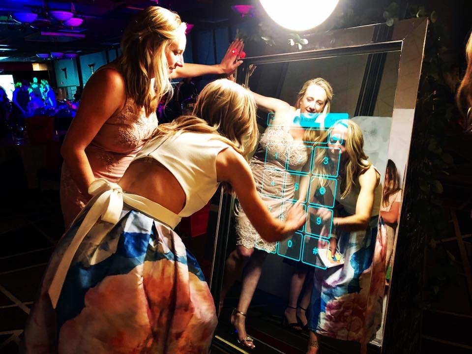 party guests interacting with a mirror photo booth