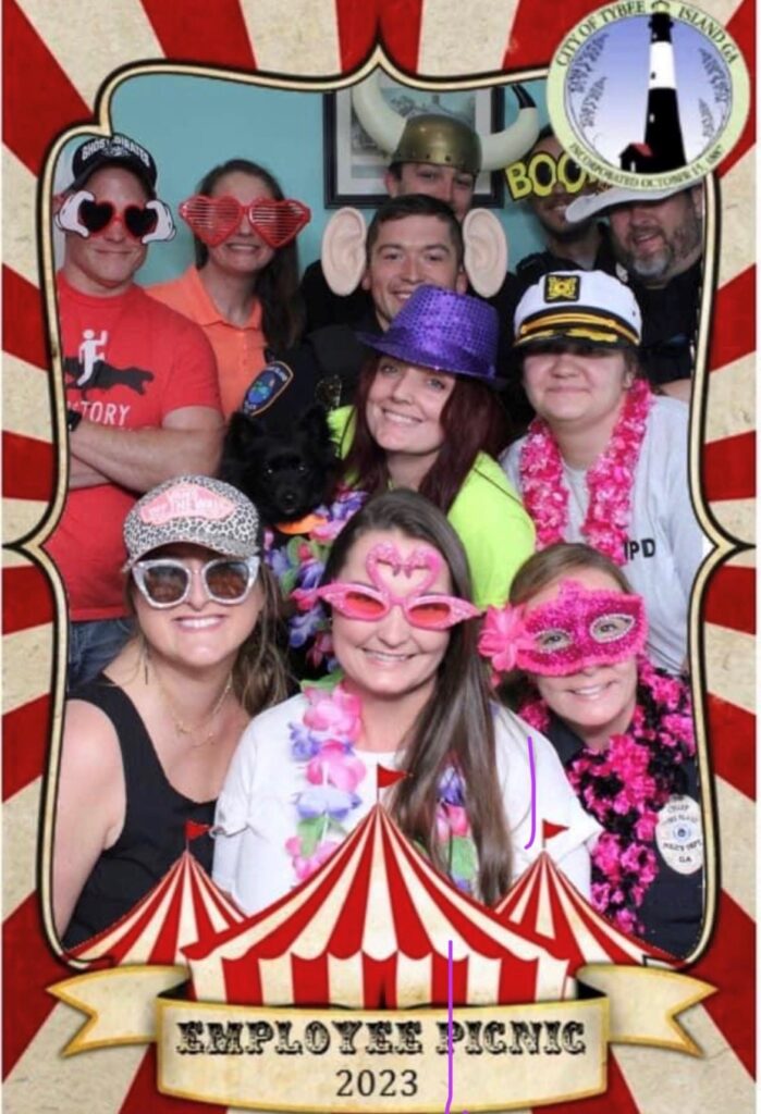 coworkers posing for photo booth at employee picnic